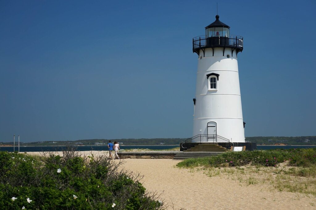 The white Edgartown Lighthouse on its sandy point under a clear blue sky