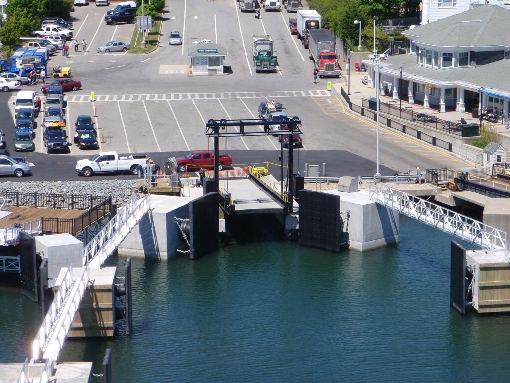 Cars lined up at the Hyannis ferry terminal, seen from above across the ferry slips and harbor water