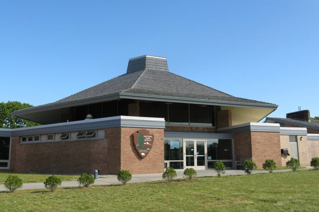 The brick and glass Salt Pond Visitor Center of Cape Cod National Seashore in Eastham under a clear sky